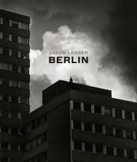Brutalist style high rise in Berlin, person standing on top, under dark sky, JASON LANGER, BERLIN, in beige and black font above.