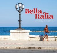 Street lamp on the Italian seafront promenade at Bari, with tanned man in blue trunks, Bella Italia, in red font to upper right.