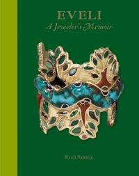 Large decorative gold bangle with tree design of green jewels, on green cover of 'EVELI A Jeweler’s Memoir', by ACC Art Books.
