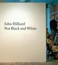 'John Hilliard: Not Black and White', in black font on white board, within office space, by Ridinghouse.