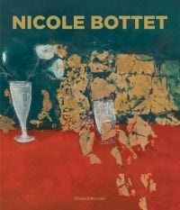 Red table cloth, with a vase of white flowers, and brown leaves, 'NICOLE BOTTET, in olive green font above, Silvana.