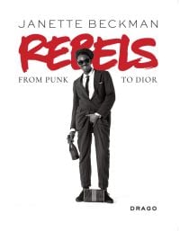 Book cover of Rebels: From Punk to Dior, featuring Slick Rick, posing with one hand grabbing crotch, the other holding champagne bottle. Published by Drago.