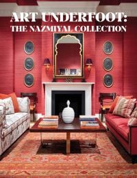 Interior designer Alexa Hampton's living room project, red wallpaper, patterned rug, fireplace, on cover of 'Art Underfoot, The Nazmiyal Collection', by Hali Publications.