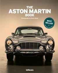 Book cover of The Aston Martin Book, with the front end of silver Aston Martin DB5 with headlights on. Published by teNeues Books.