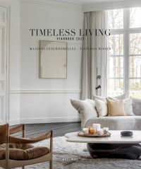 White and cream interior living room with low coffee table, on cover of 'Timeless Living Yearbook 2023', by Beta-Plus.