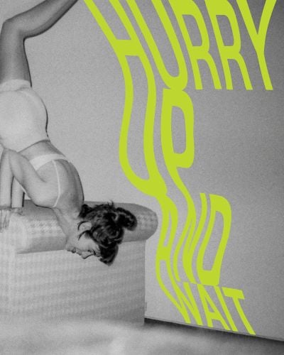 White female in underwear performing handstand on arm rest of sofa, on cover of 'Hurry Up and Wait', by Verlag Kettler.