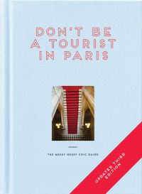Aerial view of red stairs leading down to black and white checked tiled floor, DON'T BE A TOURIST IN PARIS, in red stencilled font above, on pale blue cover.