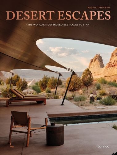 Canvas canopy over decking with sun-loungers looking across a desert, on cover of 'Desert Escapes', by Lannoo Publishers.