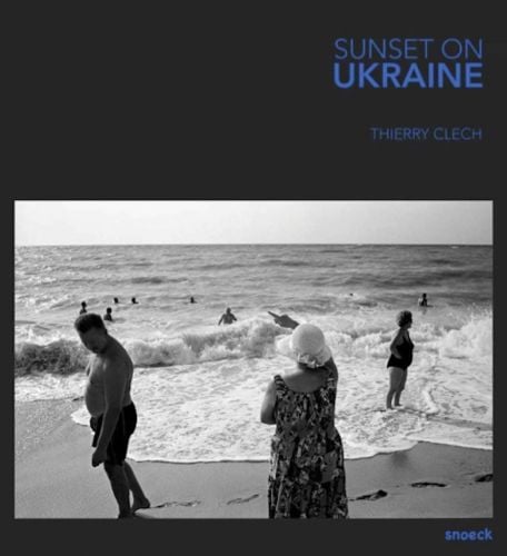 People paddling in the sea at a beach in Odessa or Crimea, on black cover, 'SUNSET ON UKRAINE', in blue font to top right corner.