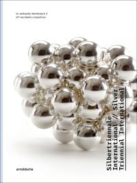 Silver metal ball bearings fused together, on white cover of 'Silver Triennial International, 20th Worldwide Competition', by Arnoldsche Art Publishers.