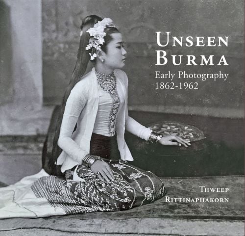 Burmese woman in traditional dress, sitting on rug, hand on cushion, on cover of 'Unseen Burma, Early Photography 1862-1962', by River Books.