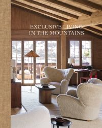 Modern interior of wood chalet with cream sofa chairs, view over mountains, on cover of 'Exclusive Living in the Mountains', by Beta-Plus.