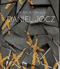 Jagged grey shapes adorned with small gold balls, 'The Art & Times of DANIEL JOCZ, in pale blue and white font above.