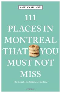 Stack of three sesame seed topped bagels, on pale green cover of '111 Places in Montreal That You Must Not Miss', by Emons Verlag.