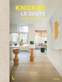 Book cover of Knokke Le Zoute Interiors, Living by the Sea, with white, open-plan kitchen/living room interior with wood floors. Published by Lannoo Publishers.