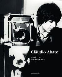 Book cover of Claudio Abate, A Project by Germano Celant, with an early image of the photographer standing behind old vintage box camera. Published by Silvana.
