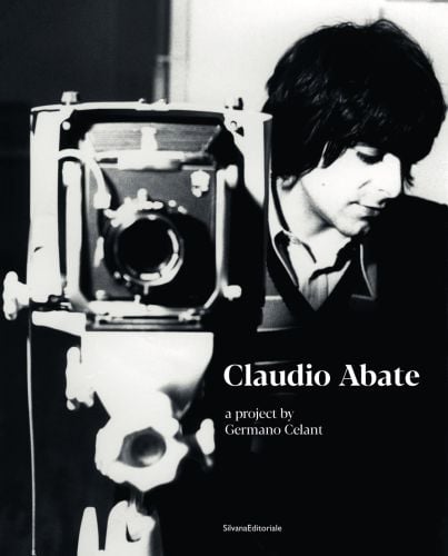 A young Claudio Abate standing behind old vintage box camera, on cover of 'Claudio Abate, A Project by Germano Celant', by Silvana.