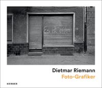 A shuttered-up shop in Ost-Berlin, 1986, 'es ist offen' spray painted on shutter door in white, on white landscape cover of 'Dietmar Riemann, Foto-Grafiker', by Kerber.