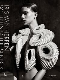 Model wearing white sculptural snake-like shoulder piece, on cover of 'Iris van Herpen, Sculpting the Senses', by Lannoo Publishers.