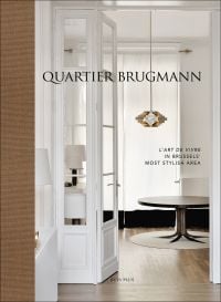 White interior living space with wood floor, coffee-table, low hanging light, on cover of 'Quartier Brugmann, L'Art de Vivre in Brussels' Most Stylish Area', by Beta-Plus.