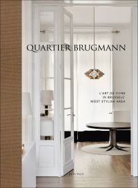 Book cover of Quartier Brugmann, L'Art de Vivre in Brussels' Most Stylish Area, with a white interior living room with wood floor, coffee-table, and low hanging light. Published by Beta-Plus.