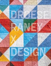 Brick wall painted with colourful triangular shapes, on cover of 'Droese Raney x Design', by ORO Editions.