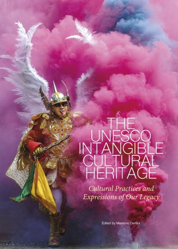 Carnival of Oruro with man dancing through pink smoke, on cover of 'The UNESCO Intangible Cultural Heritage, Cultural Practices and Expressions of our Legacy', by White Star.