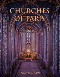 The atmospheric gothic interior of Sainte-Chapelle in Paris, stained glass windows with fleurs de lys ceiling decoration, on cover of 'Churches of Paris', by ACC Art Books.