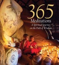 Two young male monks in red robes holding lit candles, sitting on a Buddha sculpture, on cover of '365 Meditations, A Spiritual Journey on the Path of Wisdom', by White Star.