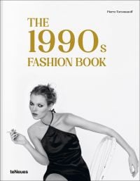 Model Kate Moss sitting on white chair, wearing a black silk dress, smoking a cigarette, on cover of 'The 1990s Fashion Book', by teNeues Books.