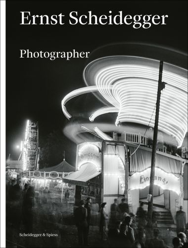 Book cover of Ernst Scheidegger, Photographer, with a night-time scene of a fairground with spinning rides. Published by Scheidegger & Spiess.