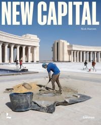 Book cover of New Capital: Building Cities From Scratch, with a construction worker mixing cement, with stone columns behind. Published by Lannoo Publishers.