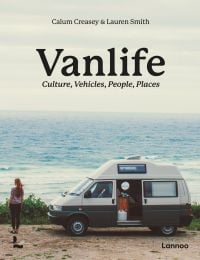 White and green camper van parked by the seaside, figure looking out to sea, on cover of 'Van Life, Culture, Vehicles, People, Places', by Lannoo Publishers.