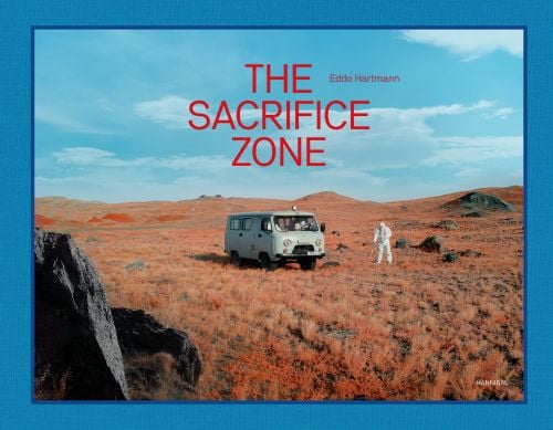 Green soviet mini van, on rocky terrain, figure in white chemical suit, on landscape cover of 'The Sacrifice Zone', by Hannibal Books.