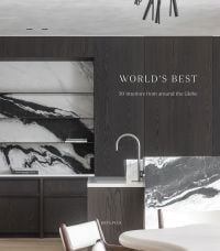 Book cover of World's Best, 50 Interiors from Around the Globe, featuring a kitchen interior of black and white marble features, and black wood, floor to ceiling storage. Published by Beta-Plus.