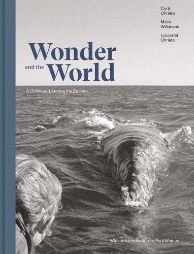 Book cover of Wonder and the World: A Childhood Among the Species, featuring a duotone photograph of a person looking at a large whale swimming near the sea's surface. Published by Verlag Kettler.