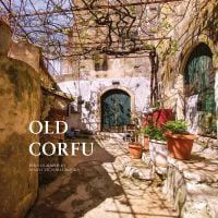 Sunny old village walkway to dark double doors of building, potted plants to right, on cover of 'Old Corfu' by ACC Art Books.