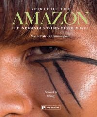 Book cover of Sue and Patrick Cunningham's Spirit of the Amazon: The Indigenous Tribes of the Xingu, featuring the eye of a tribesman with black tribal marks below. Published by Papadakis.