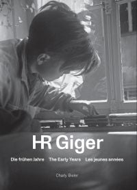 Book cover of HR Giger: The Early Years, with a young Giger playing with a train set. Published by Scheidegger & Spiess.