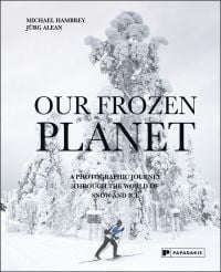 Book cover of Our Frozen Planet: A Photographic Journey Through the World of Snow and Ice, with a skier walking through a snow covered landscape. Published by Papadakis.