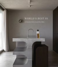 Book cover of World's Best II: 50 Interiors From Around the Globe, featuring a minimalist interior with marble table and long white drapes. Published by Beta-Plus.