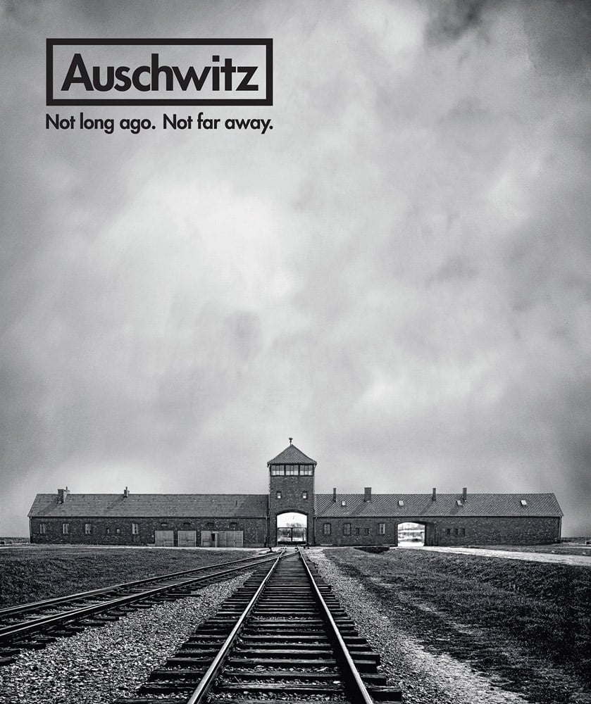 Book cover of Auschwitz: Not Long Ago. Not Far Away, with the train tracks heading towards the Auschwitz II (Birkenau) concentration camp. Published by Abbeville Press.
