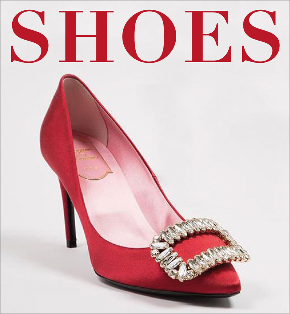 Red stiletto heeled shoe with pink lining and a clear jewel encrusted brooch on the toe area with Shoes in red capital letters above