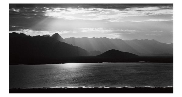 Book cover of Chasing the Mountain Light: A Life Photographing Wild Places, with a snow covered mountain landscape. Published by Abbeville Press.