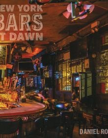 Dark interior of 7B Horseshoe Bar aka Vazacs with juke box, on cover of Daniel Root's photobook, 'New York Bars at Dawn', by Abbeville Press.