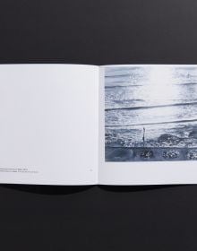 Book cover of Marguerite Horner's Numinous, with watercolor of seascape with figure on paddleboard. Published by Hurtwood Press Ltd.