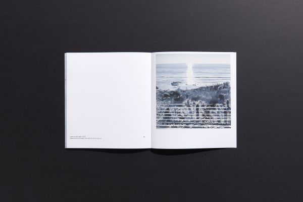 Book cover of Marguerite Horner's Numinous, with watercolor of seascape with figure on paddleboard. Published by Hurtwood Press Ltd.