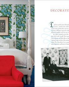 Dark green wall interior with ornate gold mirror, white fire place, floral curtains and cream lamps with Romance and Rhododendrons in white and pink font above