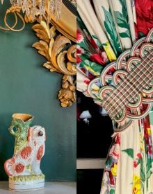 Dark green wall interior with ornate gold mirror, white fire place, floral curtains and cream lamps with Romance and Rhododendrons in white and pink font above