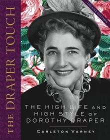 Dorothy Draper in hat and large necklace, smiling at camera, THE DRAPER TOUCH, in gold font on purple border to left edge.